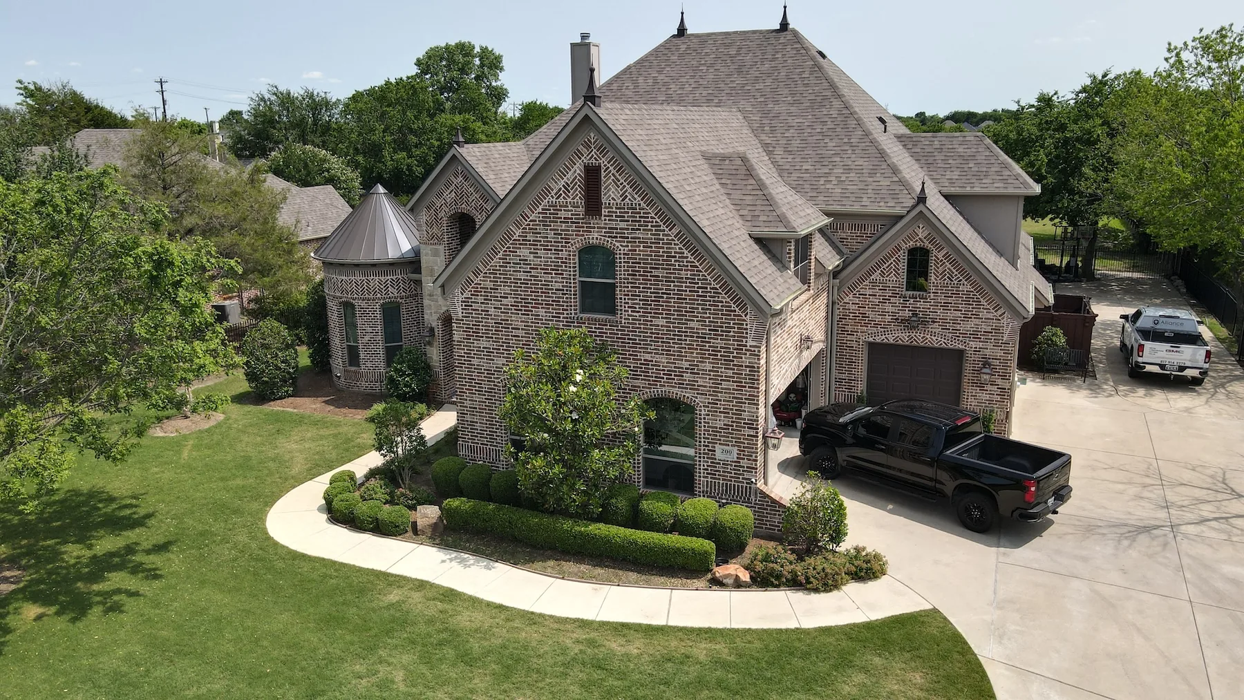 North Texas home with an asphalt architectural shingle roof and an Alliance Metal Roofing truck at the property
