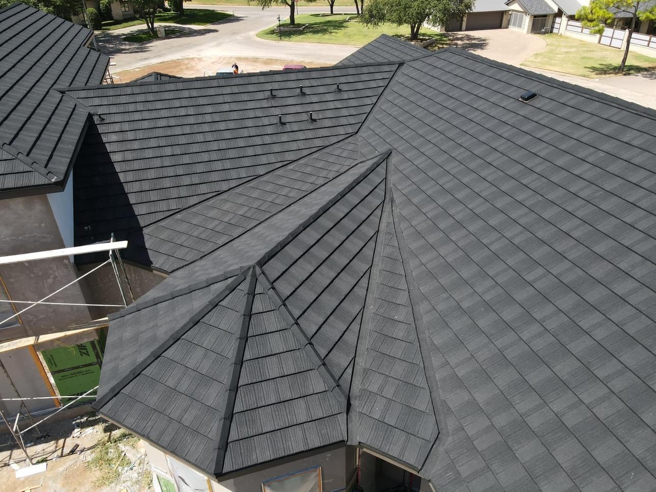 Close aerial view of a finished dark stone-coated steel roof